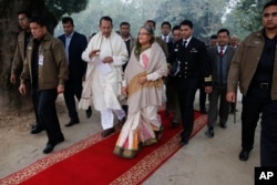 FILE - Bangladesh’s Prime Minister Sheikh Hasina, center, walks with Information Minister Hasanul Haq Inu as she arrives for a press conference in Dhaka on Jan. 6, 2014, following her ruling party's victory in one of the most violent elections in the country's history.