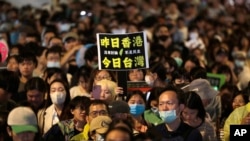 Seorang demonstran membawa poster bertuliskan "Kemarin Hong Kong. Sekarang Taiwan," dalam aksi protes di luar gedung parlemen di Taipei, Taiwan, pada 28 Mei 2024. (Foto: AP/Chiang Ying-ying)