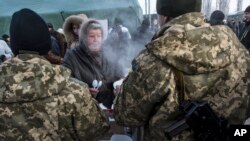 Ukrainian servicemen give out free food to local residents in Avdiivka, eastern Ukraine, Feb. 1, 2017. Freezing residents of the eastern Ukraine town battered by an upsurge in fighting between government troops pro pro-Russia rebels flocked to a humanitarian aid center Wednesday to receive food and warm up.