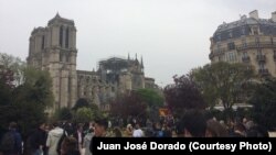 Residentes de París y turistas observan la Catedral de Notre Dame dañada por un incendio el lunes, 15 de abril de 2019.