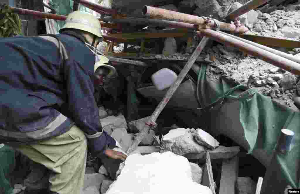Rescuers search for survivors amongst the rubble of a collapsed building in the Kariakoo district of central Dar es Salaam, Tanzania, March 29, 2013. 