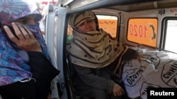 Rukhsana Bibi cries while sitting next to the body of her daughter Madiha, a worker of an anti-polio drive campaign, in an ambulance outside Jinnah Hospital in Karachi December 18, 2012.