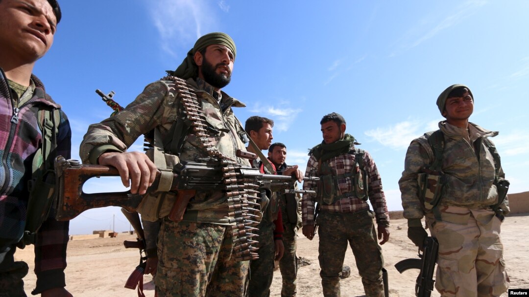 Syria Democratic Forces fighters carry their weapons in a village on the outskirts of al-Shadadi town, Hasaka countryside, Syria, Feb. 19, 2016. 