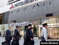Transport ministry officials arrive at Mitsubishi Motors Corp.'s headquarters building for a raid after the company admitted to manipulating test data to overstate the fuel economy, in Tokyo, Japan, May 13, 2016.