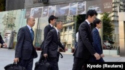 Transport ministry officials arrive at Mitsubishi Motors Corp.'s headquarters building for a raid after the company admitted to manipulating test data to overstate the fuel economy, in Tokyo, Japan, May 13, 2016. 