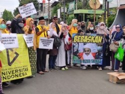 Sejumlah pendukung Muhammad Rizieq Shihab berorasi di dekat Pengadilan Negeri Jakarta Timur menuntut agar Rizieq dibebaskan, Kamis, 24 Juni 2021. (Foto: Indra Yoga/VOA)