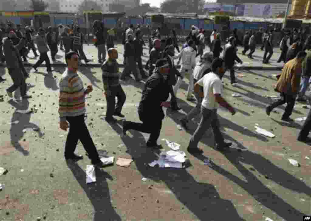 Demonstrators leave during clashes between pro-government supporters and anti-government protestors in Cairo, Egypt, Wednesday, Feb.2, 2011. Several thousand supporters of President Hosni Mubarak, including some riding horses and camels and wielding whips
