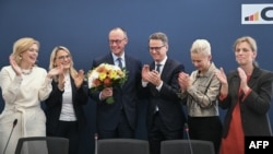 El líder de la Unión Demócrata Cristiana (CDU) de Alemania y el principal candidato del partido a Canciller Friedrich Merz (3. L) es aplaudido por el Secretario General de la CDU, Carsten Linnemann (3. R) y los miembros de la junta del partido.