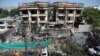 Afghan municipality workers clean debris in front of the damaged buildings a day after Taliban fighters attacked the offices of a U.-based aid organization in Kabul, May 9, 2019
