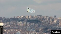 A helicopter carrying an election banner of Turkey's ruling AK Party (AKP) mayoral candidate and current mayor Melih Gokcek flies over Ankara, March 18, 2014.