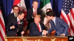 El presidente Donald Trump, centro, saluda al primer ministro de Canadá, Justin Trudeau, derecha, y al presidente de México, Enrique Peña Nieto, izquierda, tras la firma del acuerdo en el marco de la cumbre del G-20 en Argentina.