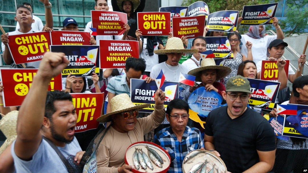 Para pengunjuk rasa meneriakkan slogan sambil menampilkan tangkapan kecil saat berlangsungnya rapat umum di Konsulat China di distrik keuangan kota Makati, untuk memprotes dugaan berlanjutnya penangkapan para nelayan Filipina di kawanan yang disengketakan di Laut Cina Selatan, meskipun protes oleh Filipina terus berlanjut, menyusul insiden sebelumnya, Senin, Juni, 11, 2018 timur Manila, Filipina. 