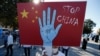 资料照片：一名来自土耳其维吾尔族社区的抗议者在伊斯坦布尔的一场抗议活动中举着反对中国的标语，抗议他们所指称的中国政府在新疆对维吾尔穆斯林的压迫。(2020年10月1日)