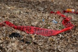 FILE - Police tape litters the ground at the scene of a shooting in Chicago, Ill..