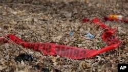 FILE - Police tape litters the ground at the scene of a shooting in Chicago, Ill., Feb. 15, 2017. 