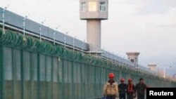 Arhiva - Radnici hodaju pored zaštitne ograde zdanja koje je zvanično poznato kao centar za razvoj profesionalnih veština u Dabančengu u Ksinjiang ujgurskoj autonomnoj oblasti, Kina, 4. septembra 2018.