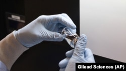 In this March 2020 image provided by Gilead Sciences, a container of the investigational drug remdesivir is visually examined at a Gilead manufacturing site in the United States. (Gilead Sciences via AP)