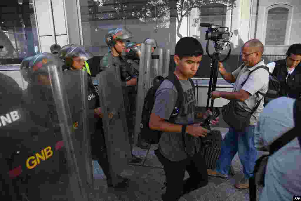 La Guardia Nacional Bolivariana de Venezuela impide que miembros de la prensa, algunos empujados con escudos, accedan al Palacio Legislativo Federal en 15 de mayo de 2019. El Palacio alberga a la Asamblea Nacional, liderada por la oposición, y a la Asamblea Nacional Constituyente progubernamental.