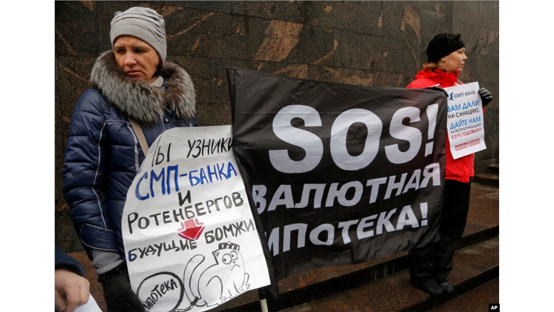 FILE - Hard-currency mortgage holders take part in a protest in front of a bank in St. Petersburg, Russia, Jan. 28, 2016.