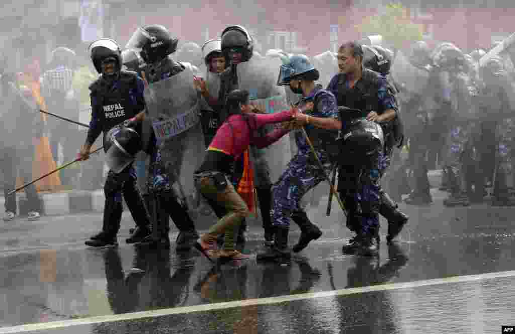 Police arrest a Hindu activist as demonstrators try to break through to a cordoned-off area near parliament&nbsp;in Kathmandu during a protest demanding that Nepal be declared a Hindu state.