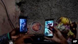 Familiares en su casa en el barrio La Guinera, de La Habana, muestran fotos de tres hermanos que están en prisión acusados de participar en protestas antigubernamentales, en Cuba, enero de 2022. [Foto de archivo]