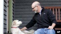 University of Washington School of Medicine researcher Daniel Promislow, the principal investigator of the Dog Aging Project grant, sits with his elderly dog Frisbee at their home in Seattle, Nov. 11, 2019. 