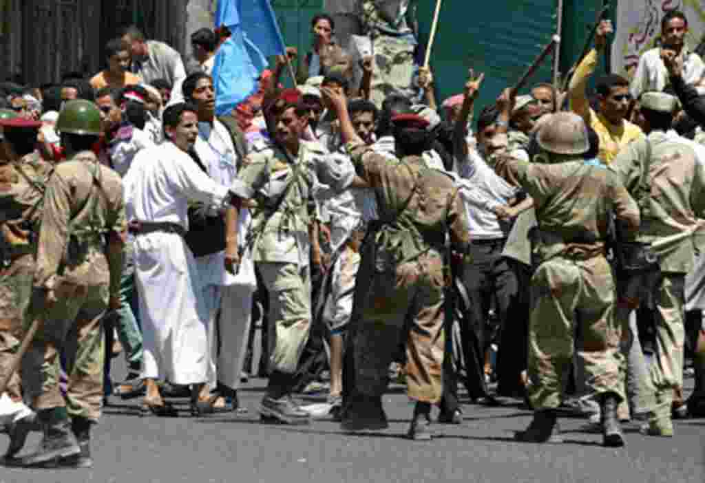 Soldiers hold back supporters of Yemen's President Ali Abdullah Saleh during clashes with anti-government protesters in the southern city of Taiz, Apr 22 2011