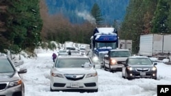 Cars and trucks are stopped in traffic on Interstate 5 near Dunsmuir, Calif., Nov. 27, 2019. Thanksgiving travel has been snarled by two powerful storms.