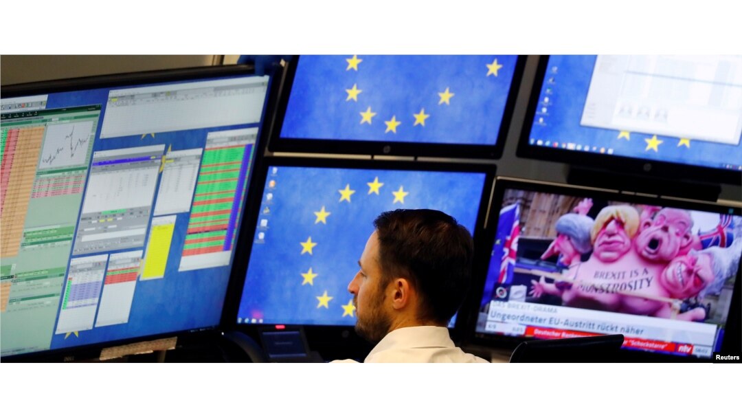 FILE - A shares trader checks his trading systems at the start of the trading session the day after the Brexit deal vote of the British parliament at the stock exchange in Frankfurt, Germany, Jan. 16, 2019.