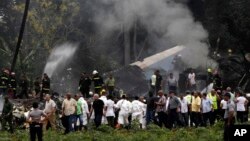 Cuba's President Miguel Diaz-Canel, third from left, walks away from the site where a Boeing 737 plummeted into a yuca field with more than 100 passengers on board, in Havana, Cuba, May 18, 2018. Cuban investigators have retrieved both black boxes from the wreckage.
