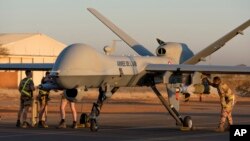 FILE — A photo provided by the French Defense Ministry communication center and taken Tuesday December 17, 2019, shows French soldiers loading a Reaper drone with two GBU 12 missiles amid preparations to leave Niger. 