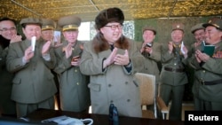 Lãnh đạo Bắc Triều Tiên Kim Jong Un vỗ tay trong cuộc giám sát hệ thống phóng tên lửa tại một địa điểm không được tiết lộ.