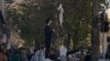 دختر معترض به حجاب، در مقابل دانشگاه تهران روسری را بر چوب گرفته است
