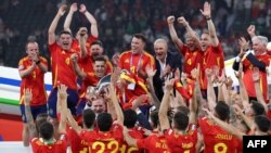 Raja Spanyol Felipe mengangkat piala dan merayakan kemenangan timnas Spanyol meraih juara turnamen sepak bola Piala Eropa dalam laga final antara Spanyol dan Inggris di Olympiastadion di Berlin, Minggu, 14 Juli 2024. (Foto: Adrian Dennis/AFP)