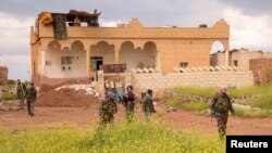 Forces loyal to Syria's President Bashar al-Assad carry their weapons as they move during what they said was an operation to push rebels from the road between Al-Safira area and Aleppo International Airport, Apr. 24, 2013.