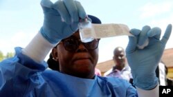 A health worker prepares an Ebola vaccine to administer to health workers during a vaccination campaign in Mbandaka, Congo, May 21, 2018. (AP Photo/John Bompengo)