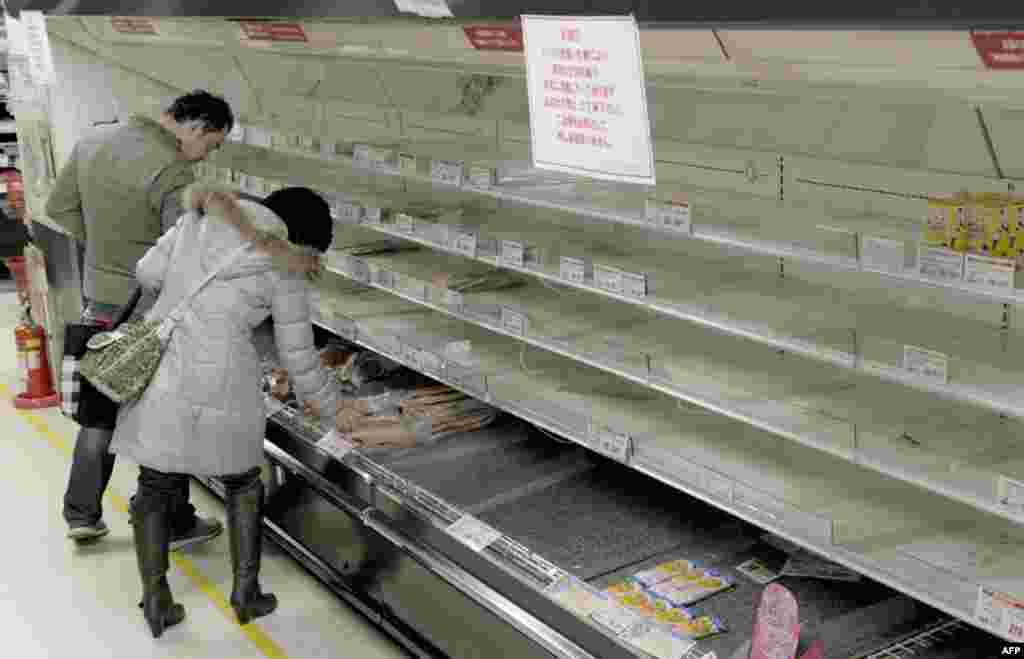 Люди скупают остатки продуктов питания с почти пустых полок магазина, Токио, 15 марта 2011г.