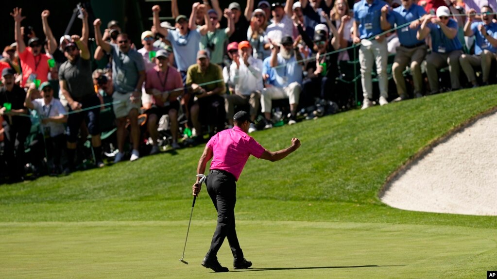 Tiger Woods celebrates during his return to professional golf after a birdie putt on the 16th green during the first round at the Masters golf tournament on Thursday, April 7, 2022, in Augusta, Ga. (AP Photo/David J. Phillip)