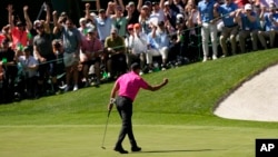 Tiger Woods celebrates during his return to professional golf after a birdie putt on the 16th green during the first round at the Masters golf tournament on Thursday, April 7, 2022, in Augusta, Ga. (AP Photo/David J. Phillip)