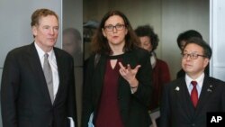 FILE - European Commissioner for Trade Cecilia Malmstroem, center, Japanese Minister for Economy, Trade and Industry Hiroshige Seko, right, and U.S. Trade Representative Robert Lighthizer, pose for photographers prior to a meeting at EU headquarters in Brussels on Saturday, March 10, 2018. 