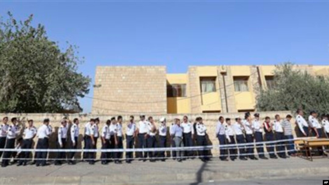 Polisi lalu lintas di wilayah Irbil, Irak, 350 kilometer utara Baghdad, terlihat antri di sebuah TPS untuk mengikuti pemilu dini untuk pasukan keamanan, Kamis (19/9).
