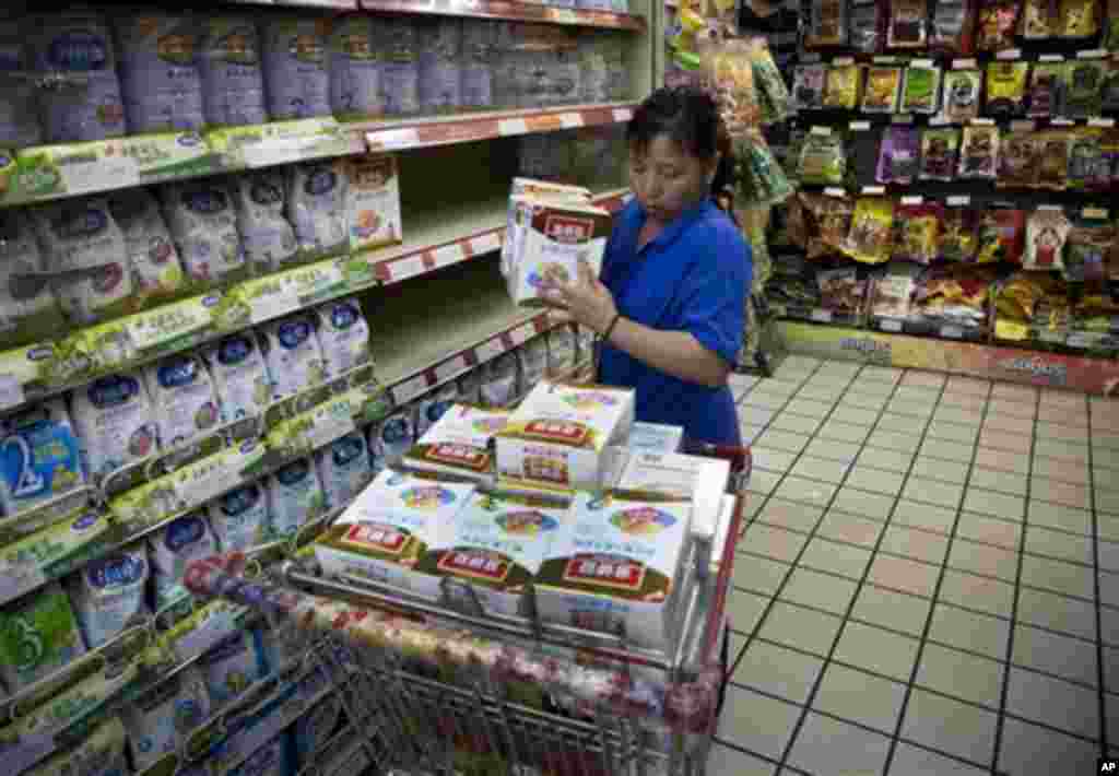 6月15日，北京某超市一名工作人员把被召回的婴儿奶粉卸下货架；一天前内蒙古伊利集团宣布召回汞含量超标的婴儿奶粉。中国接连发生毒奶粉、毒胶囊和地沟油等食品药品安全事件。（美联社照片）