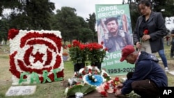 A man places flowers on the grave of slain rebel leader Jorge Briceno, known as Mono Jojoy, during an homage by former members of the Revolutionary Armed Forces of Colombia, FARC, to one of their most prominent military strategists at a cemetery in southern Bogota, Colombia, Sept. 22, 2017.