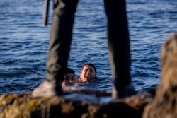 Seorang penjaga sipil Spanyol menunggu para migran di daerah kantong Spanyol Ceuta, dekat perbatasan Maroko dan Spanyol. (Foto: AP)