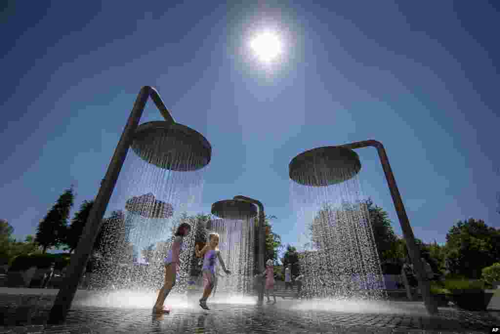 Children cool off in a public fountain in Vilnius, Lithuania, June 19, 2021.