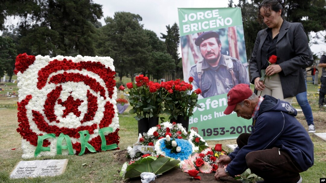 A man places flowers on the grave of slain rebel leader Jorge Briceno, known as Mono Jojoy, during an homage by former members of the Revolutionary Armed Forces of Colombia, FARC, to one of their most prominent military strategists at a cemetery in southern Bogota, Colombia, Sept. 22, 2017.