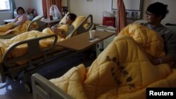 Hsu Bi-chi and her sons Chang Chun-po and Chang Chun-jung (L-R) rest at a hospital after an earthquake hit Tainan, southern Taiwan, Feb. 8, 2016. 