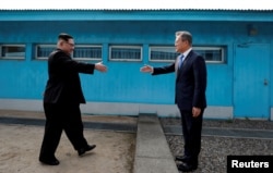 FILE - South Korean President Moon Jae-in and North Korean leader Kim Jong Un, left, approach to shake hands ahead of a meeting at the truce village of Panmunjom inside the demilitarized zone separating the two Koreas, South Korea, April 27, 2018.