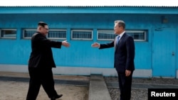 FILE - South Korean President Moon Jae-in and North Korean leader Kim Jong Un, left, are about to shake hands on their first meeting at the truce village of Panmunjom inside the demilitarized zone separating the two Koreas, South Korea, April 27, 2018. 