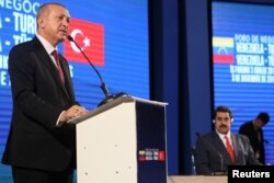 Turkish President Recep Tayyip Erdogan speaks during a business forum, next to Venezuela's President Nicolas Maduro, in Caracas, Venezuela, Dec. 3, 2018.